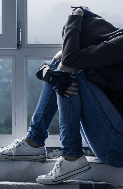 Verzweifelte Jugendliche verbirgt ihr Gesicht