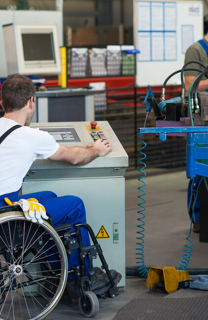 Rollstuhlfahrer vor Maschinen