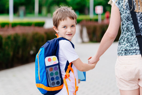 Boy with his mother at road to school.