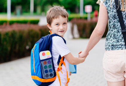 Boy with his mother at road to school.