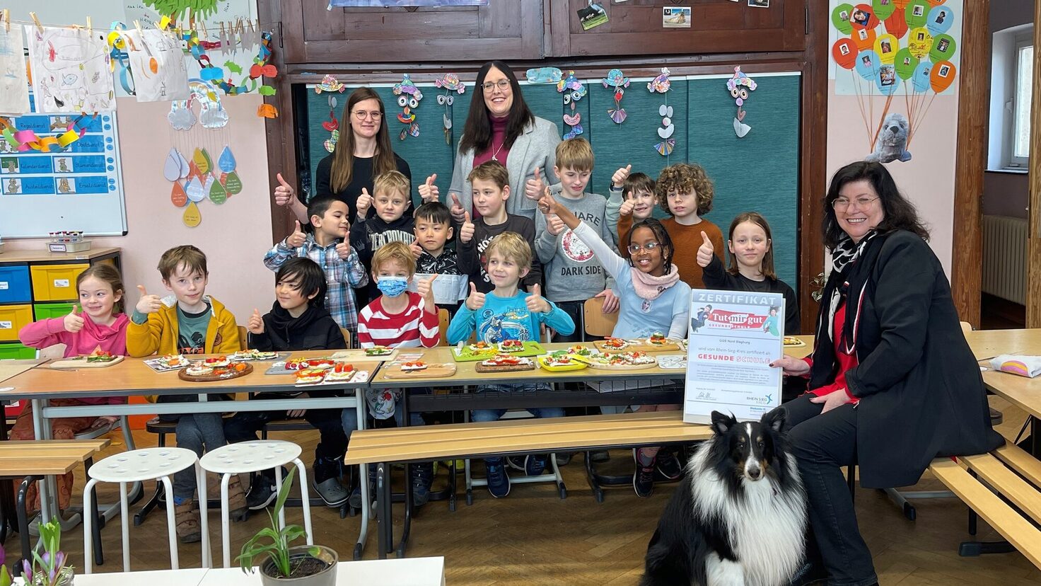 Klasse 2c mit Schulleiterin Frau Schäfer, den TMG-beauftragten Lehrerinnen Frau Jungbluth und Frau Heinrichs sowie dem Schulhund Barney