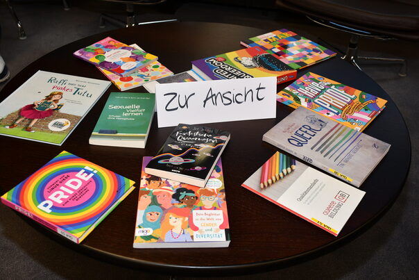 Das Bild zeigt verschiedene Bücher und Broschüren zum Thema Queere Lebenswelten