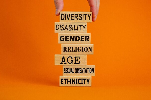 Wörter auf Holzblöcken: Diversität, Behinderung, Geschlecht, Religion, Alter, Sexuelle Orientierung, Ethnizität