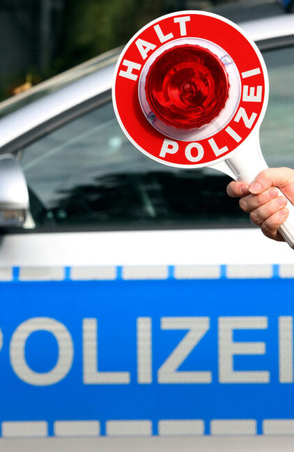 Polizeikelle vor Polizeifahrzeug