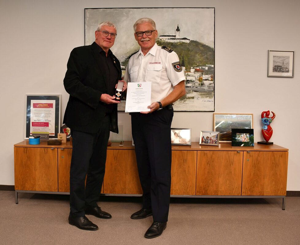 Landrat Sebastian Schuster überreicht Kreisbrandmeister Stefan Gandelau das Feuerwehr-Ehrenzeichen in Gold