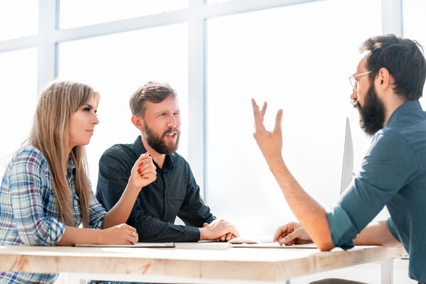 employer discusses business documents with employees at a meeting