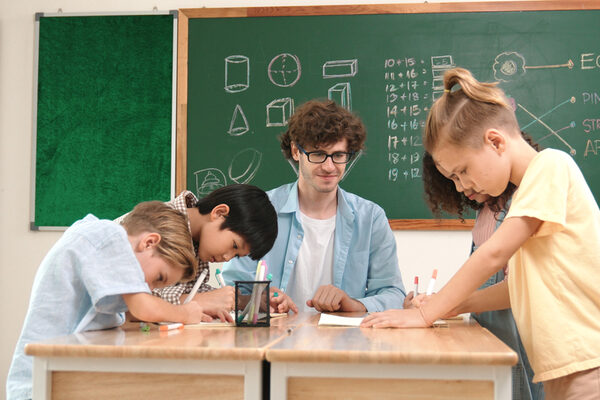 Smart teacher explain idea while diverse children drawing mind map. Pedagogy.