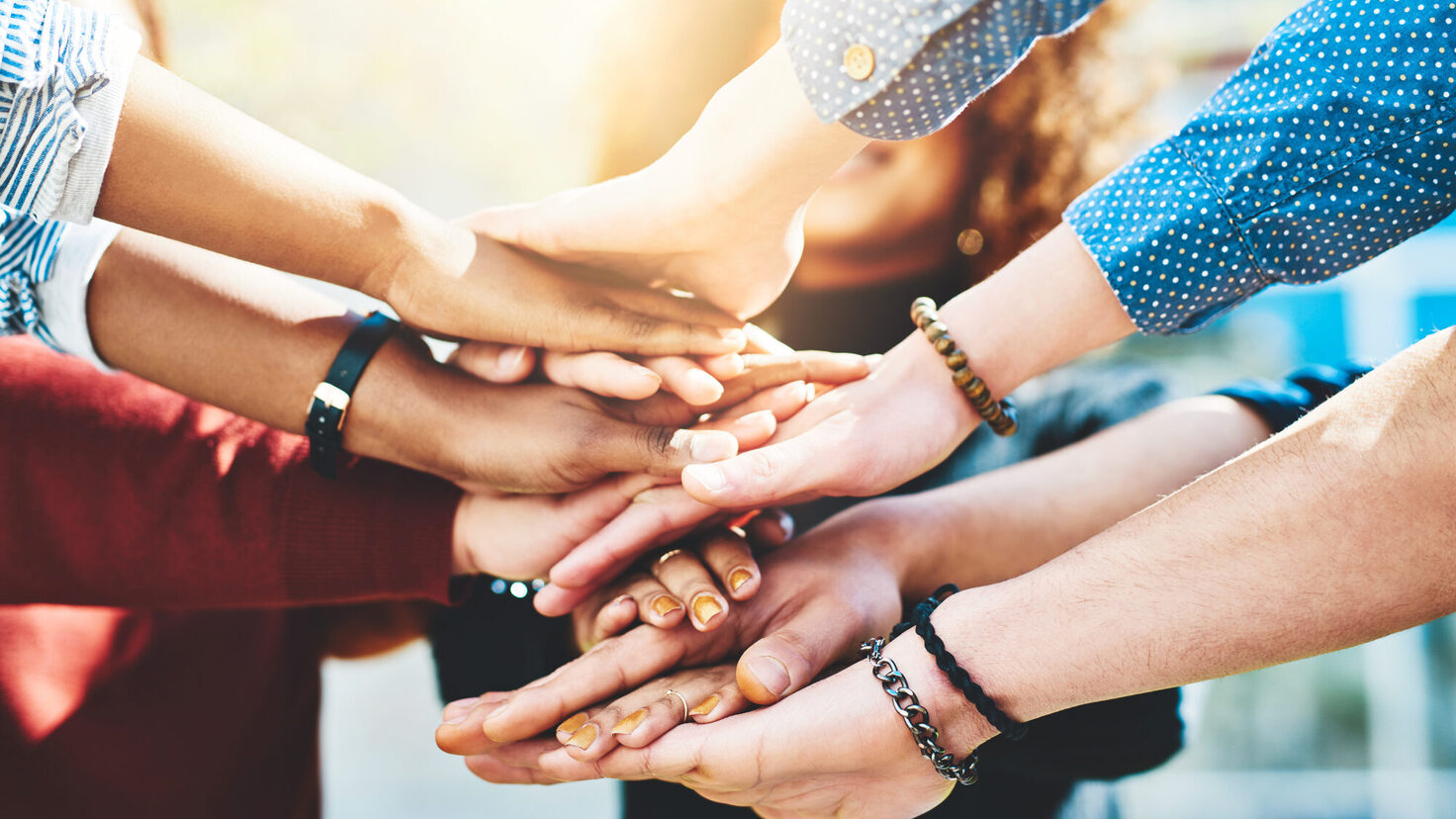 College students, closeup or stack of hands in outdoor campus meeting for group teamwork. People, lens flare or university friends in collaboration for learning together or education study at school